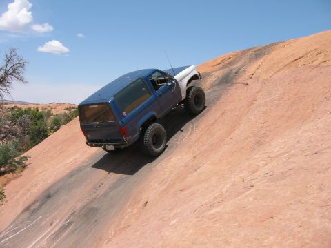 1997 Ford Ranger - Off-road SUV navigates a challenging rocky terrain in a desert landscape.