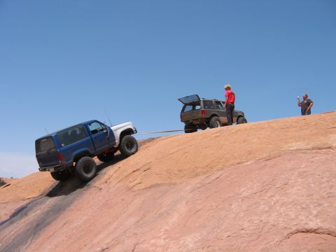 1997 Ford Ranger - Two off-road vehicles are being used to help one climb a steep, rocky terrain under a clear blue sky.
