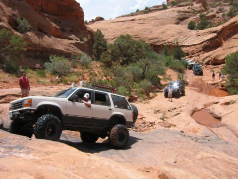1997 Ford Ranger - Several modified SUVs tackle a challenging off-road course in a desert canyon landscape.