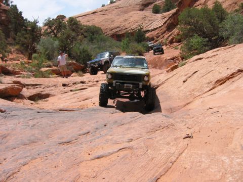 1997 Ford Ranger - Multiple off-road vehicles traverse a challenging rocky terrain in a desert landscape.