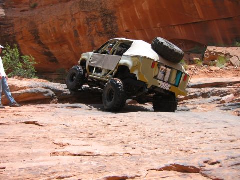 1997 Ford Ranger - A heavily modified off-road vehicle tackles a challenging rocky trail in a desert canyon.