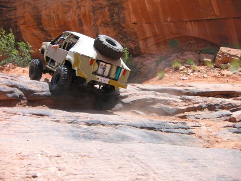 1997 Ford Ranger - Modified off-road vehicle navigates a rocky trail in a desert landscape.