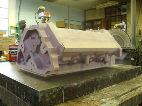 1972 Ford Ranchero - A purple tooling-board foundry pattern for a cylinder head or engine block sits on a steel surface plate in a pattern shop, its machined ca…