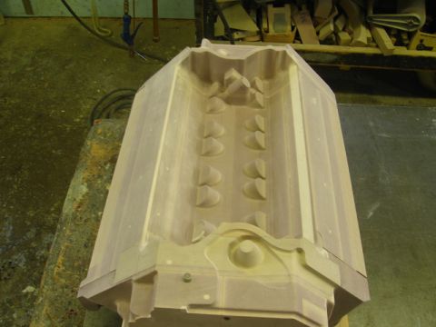 1972 Ford Ranchero - Light-colored wooden foundry casting pattern for a V-engine component sitting on a workbench, viewed from above into the valley. Machined r…