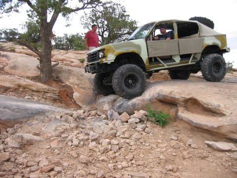 1997 Ford Ranger - A heavily modified truck navigates a rocky trail in a desert landscape.