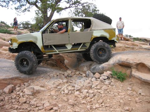 1997 Ford Ranger - A heavily modified truck with a custom canvas top navigates a challenging rocky trail.