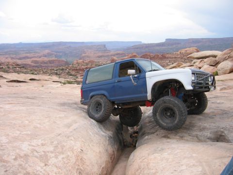 1997 Ford Ranger - Modified SUV navigates a narrow gap between rocks in a desert landscape.