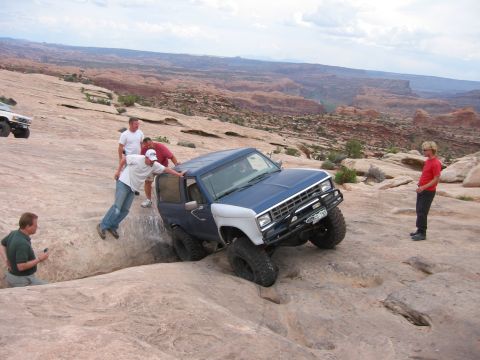 1997 Ford Ranger - Off-road enthusiasts assist a vehicle navigating a challenging rocky trail in a desert landscape.