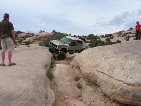 1997 Ford Ranger - A modified off-road vehicle navigates a challenging rocky terrain, with spectators observing the action.