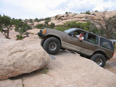 1997 Ford Ranger - A brown Ford Explorer navigates a rocky trail, demonstrating its off-road capabilities.