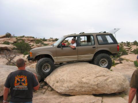1997 Ford Ranger - Tan Ford Explorer navigates rocky terrain with its rear hatch open, suggesting an off-road adventure.