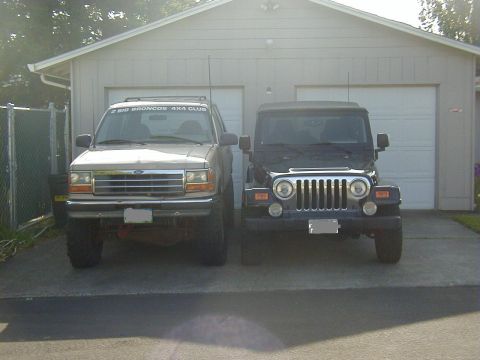 1994 Ford Explorer - Two SUVs are parked in front of a garage, one is a Ford Explorer and the other is a Jeep Wrangler.