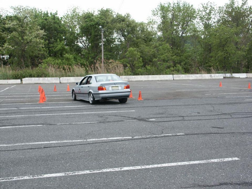 Silver BMW E36 sedan navigating autocross course