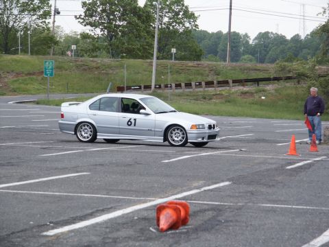 2001 Mercury Grand Marquis - A silver BMW E36 sedan is seen on an asphalt lot with orange cones, possibly during an autocross event.