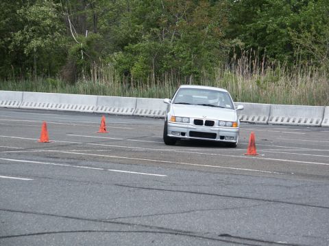 2001 Mercury Grand Marquis - A silver BMW E36 sedan navigates a course marked by orange cones on a paved track.
