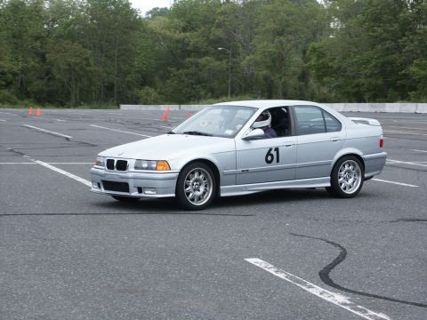 2001 Mercury Grand Marquis - A silver BMW sedan, marked with the number 61, navigates an autocross course.
