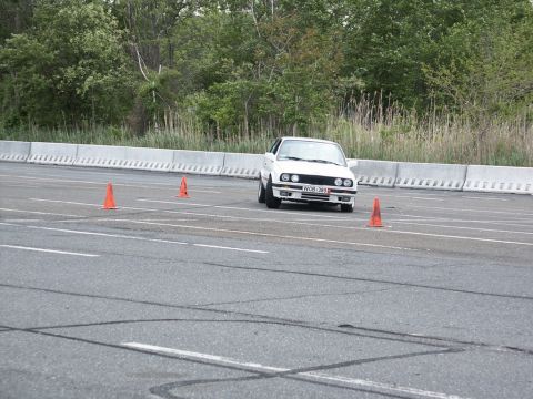 2001 Mercury Grand Marquis - A white sedan navigates a course marked by orange cones on a paved track.