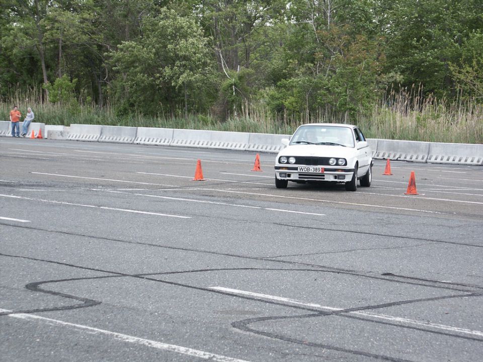 White BMW E30 front view on race track with orange cones