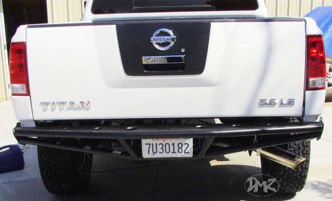 1984 Ford Bronco - Rear view of a white Nissan Titan pickup truck with a custom bumper and exhaust.