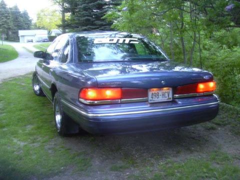 1996 Ford Crown Victoria - Rear view of a 1996 Ford Crown Victoria parked outdoors on a dirt and grass area.