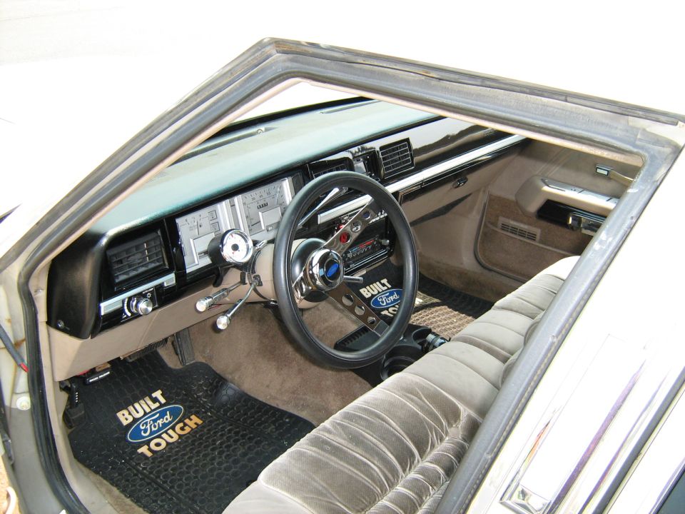 Interior dash and steering wheel of an older Ford truck with bench seat
