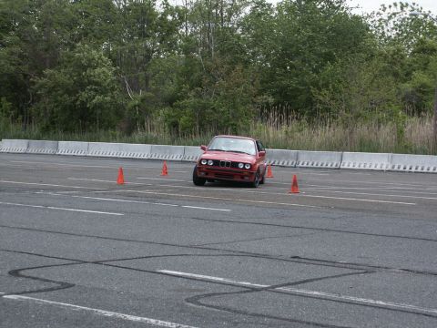 2001 Mercury Grand Marquis - A red BMW E30 coupe navigates an autocross course marked by orange cones.