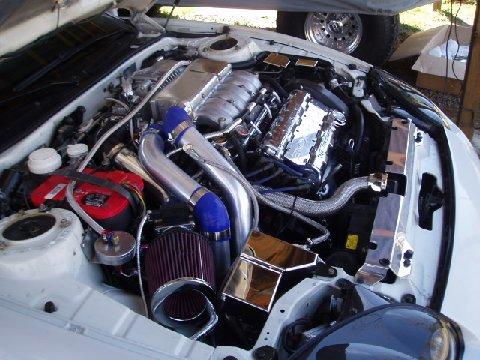 1994 Dodge Stealth - The engine bay shows a complex setup with a prominent supercharger and polished components.