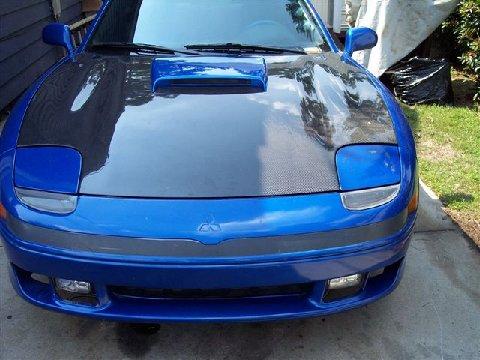 1994 Dodge Stealth - Front view of a blue sports car a carbon fiber hood and the Supermotors logo at the bottom.