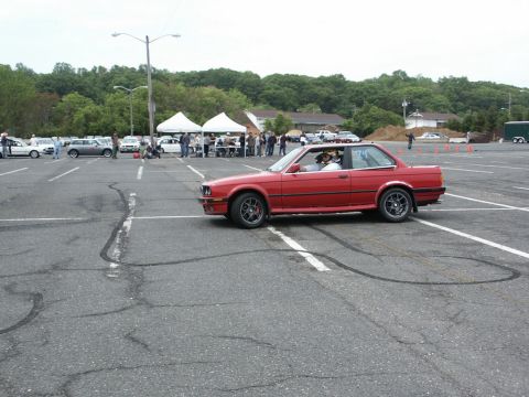 2001 Mercury Grand Marquis - A red coupe is seen performing donuts in a parking lot during an event.