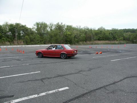 2001 Mercury Grand Marquis - A red coupe navigates a course marked by orange cones on a cloudy day.