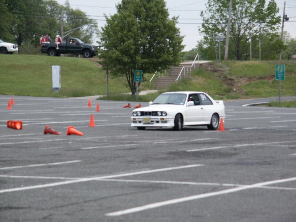 White BMW E30 M3 navigating autocross course