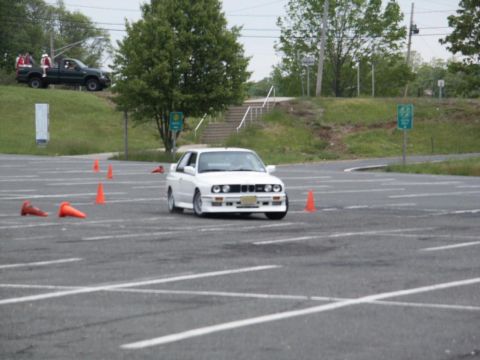 2001 Mercury Grand Marquis - A white BMW E30 M3 is seen on a wet asphalt course, likely during an autocross event.