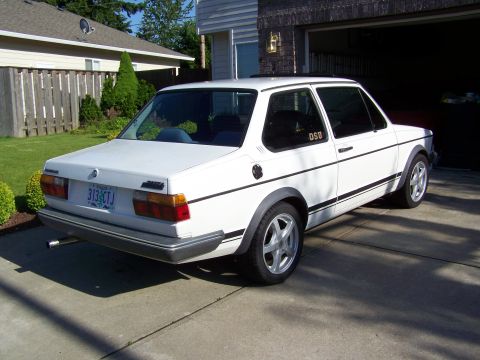 1984 Volkswagen Jetta - A white 1984 Volkswagen Jetta is parked in a driveway with the garage door open.