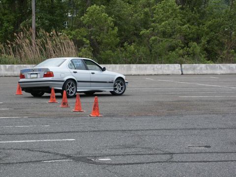 2001 Mercury Grand Marquis - A silver BMW sedan is seen maneuvering around orange cones during an autocross event.