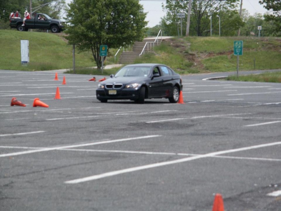 Black BMW sedan navigating a course marked by orange cones