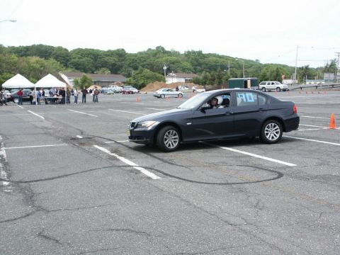 2001 Mercury Grand Marquis - A dark sedan with the number 90 on its window is seen on an asphalt lot with tire marks, possibly during an event.