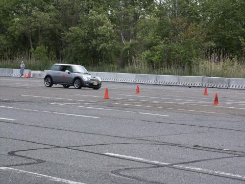 2001 Mercury Grand Marquis - A Mini Cooper navigates a cone course on a sunny day.