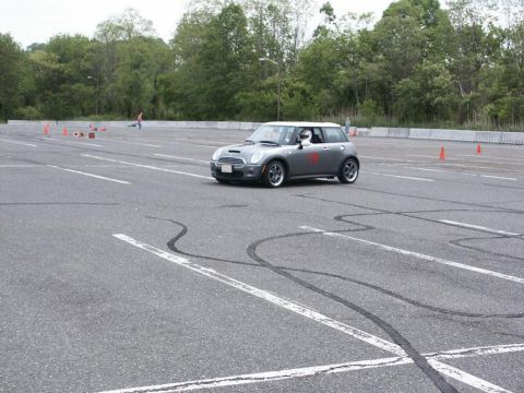 2001 Mercury Grand Marquis - A Mini Cooper S navigates a course marked by cones on a closed asphalt track.