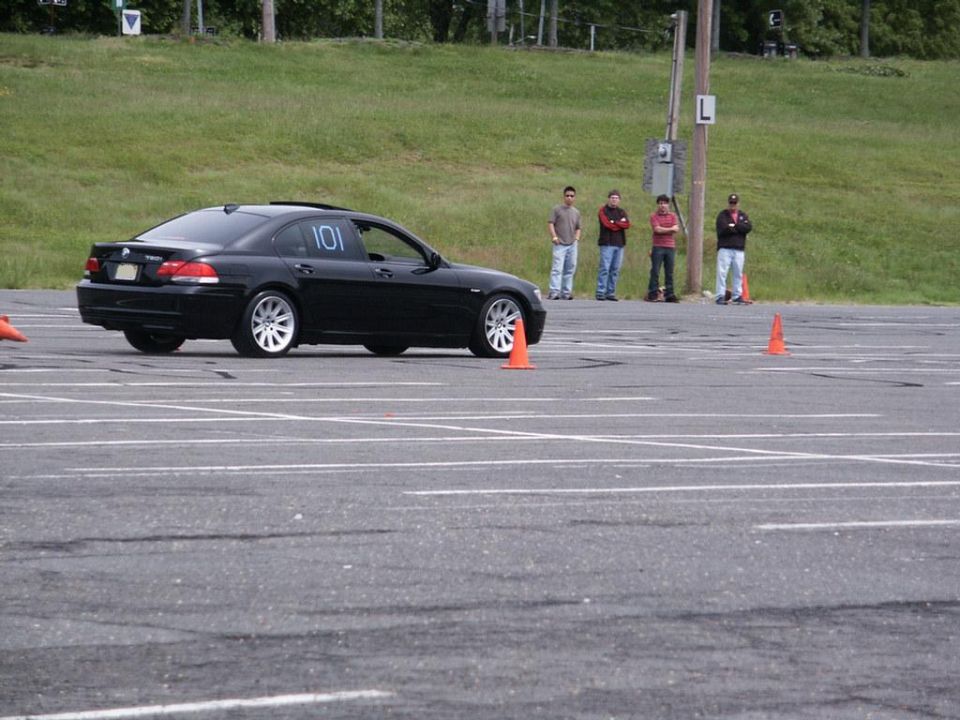 Black sedan with number 101 on the door, seen from the side at an autocross event