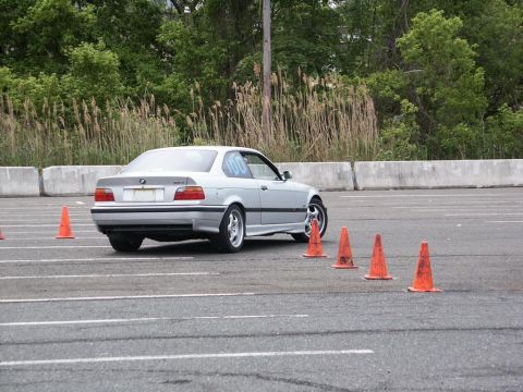 2001 Mercury Grand Marquis - Silver BMW E36 coupe on an autocross course, marked with racing number 100.