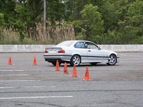 2001 Mercury Grand Marquis - Silver BMW E36 coupe with racing number 100 on door navigates an autocross course.