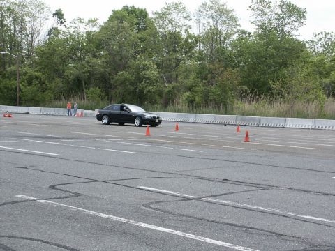 2001 Mercury Grand Marquis - A black sedan navigates an autocross course marked by orange cones on a cloudy day.