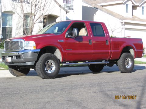 2004 Ford F-250 - This red 2004 Ford F-250 crew cab pickup truck is shown from the front three-quarter view.