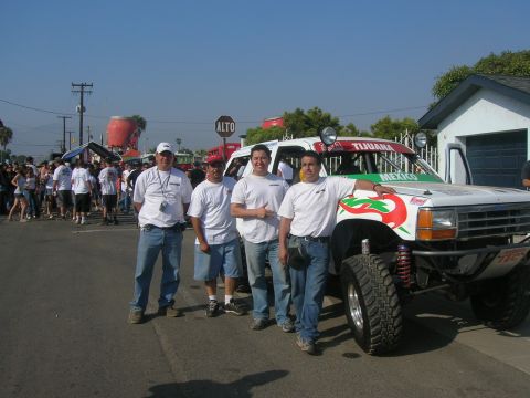 1992 Ford Explorer - Four men stand next to a modified 1992 Ford Explorer race truck with 'Tijuana' and 'Mexico' decals.