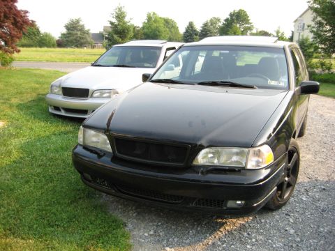 1993 Ford Probe - Two Volvo wagons are parked side-by-side on a sunny day, with one in the foreground and another in the background.