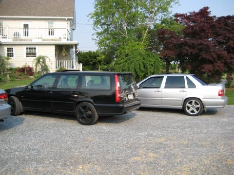 1993 Ford Probe - Two Volvo vehicles are parked in a gravel driveway outside a house.