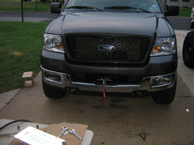 Front view of a dark gray Ford F-150 truck with a black grille and chrome bumper