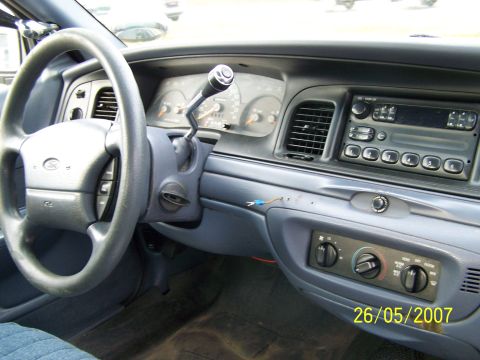 2003 Ford Crown Victoria - The interior of a 2003 Ford Crown Victoria is visible, including the dashboard, steering wheel, and center console.