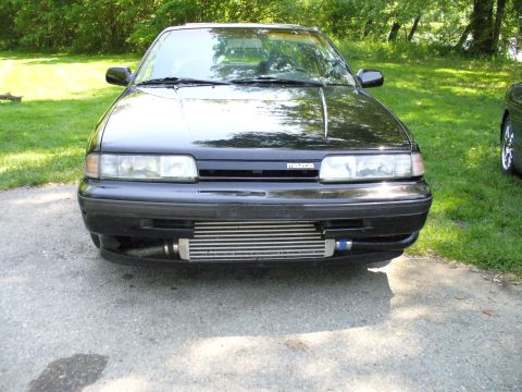 1991 Ford Probe - A black car with a prominent aftermarket intercooler and a Mazda badge is shown from the front.