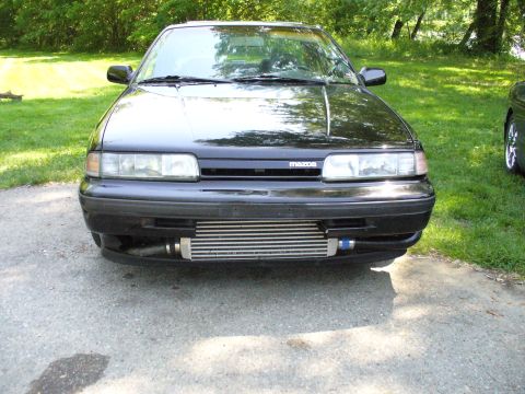 1991 Ford Probe - Front view of a modified black car with an aftermarket intercooler and a Mazda badge.